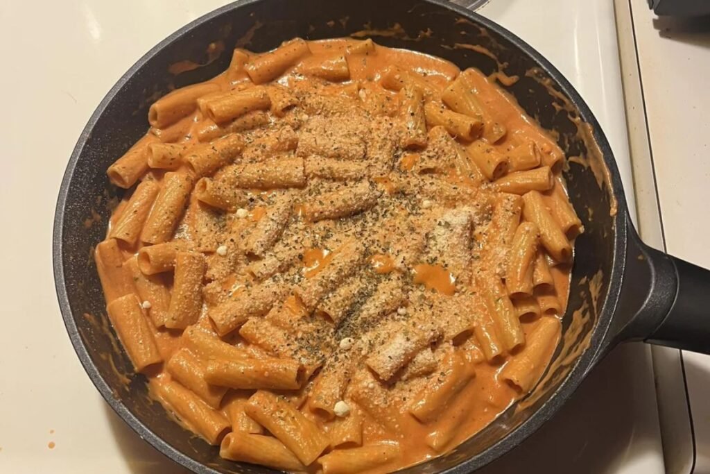 creamy tomato pasta in a bowl with parmesan and basil
