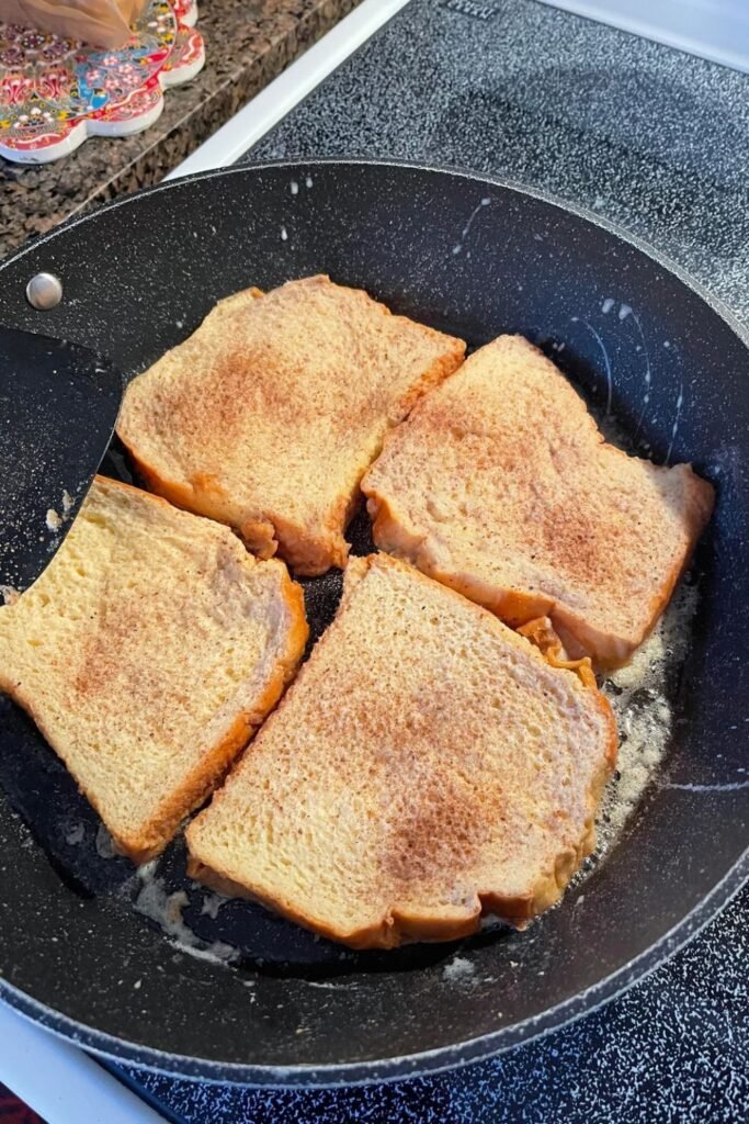 French toast cooking in skillet until golden brown