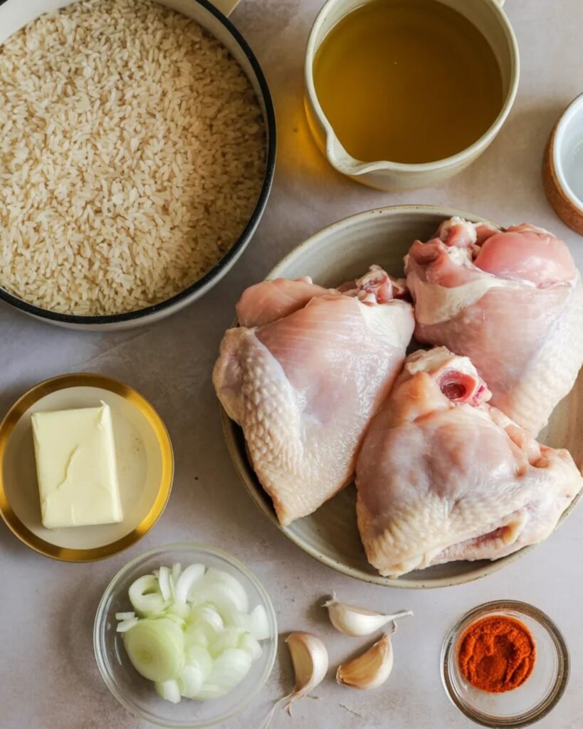 Ingredients for garlic butter chicken and rice including chicken thighs, rice, garlic, butter, and onion