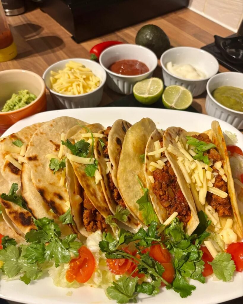 Ground beef tacos filled with seasoned beef lettuce tomatoes and cheese