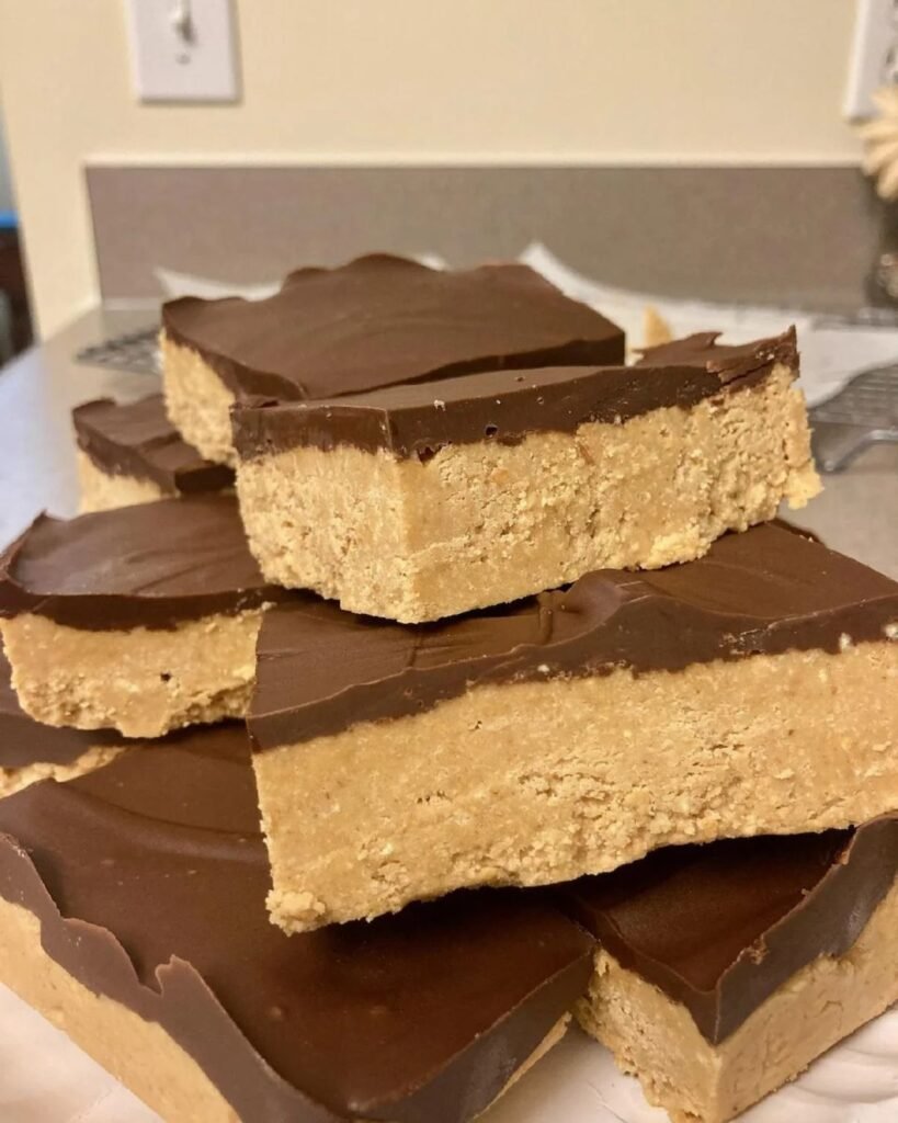 no bake chocolate peanut butter bars stacked on plate with soft fudgy layers